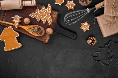 Noel ev yapımı gingerbread çerezleri, baharatlar ve kesme tahtası ile kopya alanı metin için koyu renk arka plan üzerinde görünümü top. Yeni yıl ve Noel kartpostalı