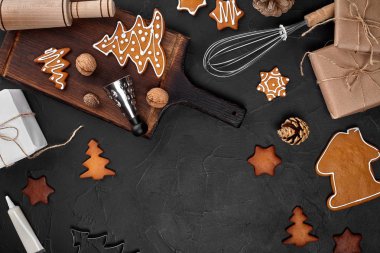 Noel ev yapımı gingerbread çerezleri, baharatlar ve kesme tahtası ile kopya alanı metin için koyu renk arka plan üzerinde görünümü top. Yeni yıl ve Noel kartpostalı