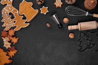 Noel ev yapımı gingerbread çerezleri, baharatlar ve kesme tahtası ile kopya alanı metin için koyu renk arka plan üzerinde görünümü top. Yeni yıl ve Noel kartpostalı