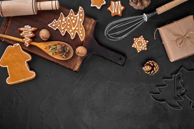Noel ev yapımı gingerbread çerezleri, baharatlar ve kesme tahtası ile kopya alanı metin için koyu renk arka plan üzerinde görünümü top. Yeni yıl ve Noel kartpostalı