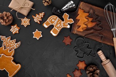 Noel ev yapımı gingerbread çerezleri, baharatlar ve kesme tahtası ile kopya alanı metin için koyu renk arka plan üzerinde görünümü top. Yeni yıl ve Noel kartpostalı