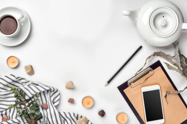 Kalem ve beyaz tabloda çay ile not etmek. Çalışma alanı. El yapımı. Üstten görünüm, düz yatıyordu.