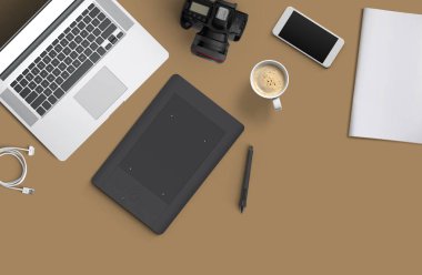 En az çalışma alanı: Laptop, fotoğraf makinesi, kahve, kamera, kalem, kalem, defter, smartphone, kopya alanı için kahverengi zemin üzerinde ileti örneği.