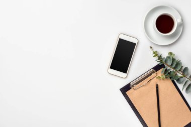 Kalem ve beyaz tabloda çay ile not etmek. Çalışma alanı. El yapımı. Üstten görünüm, düz yatıyordu.