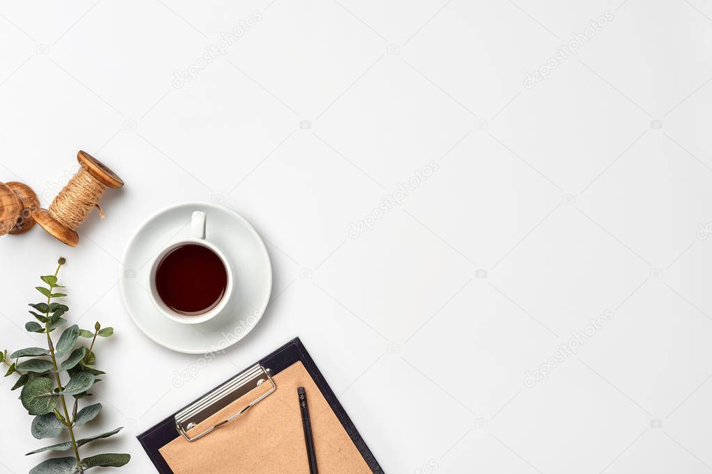 Cup with a ready tea on a white table. Top view, flat lay. Copy space