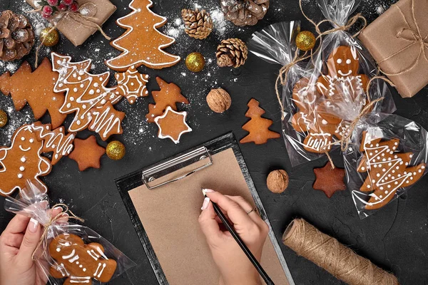 Árvore de biscoito de Natal feito com estrela cortador de biscoito bolo de gengibre ano novo decorado com arco de corda e forma para cortar biscoitos na mesa preta . — Fotografia de Stock