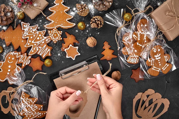 Árvore de biscoito de Natal feito com estrela cortador de biscoito bolo de gengibre ano novo decorado com arco de corda e forma para cortar biscoitos na mesa preta . — Fotografia de Stock