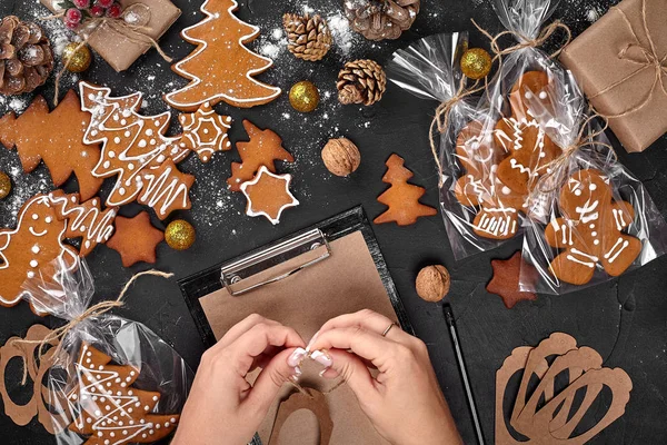 Árvore de biscoito de Natal feito com estrela cortador de biscoito bolo de gengibre ano novo decorado com arco de corda e forma para cortar biscoitos na mesa preta . — Fotografia de Stock