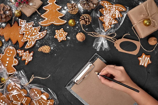 Árvore de biscoito de Natal feito com estrela cortador de biscoito bolo de gengibre ano novo decorado com arco de corda e forma para cortar biscoitos na mesa preta . — Fotografia de Stock