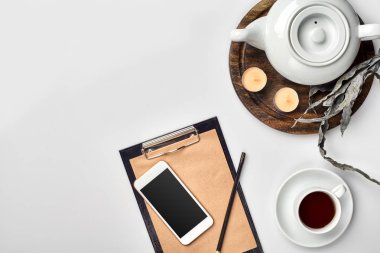 Kraft kağıt, cep telefonu, siyah çay, kopya alanı beyaz zemin üzerine gözlük ile defter.