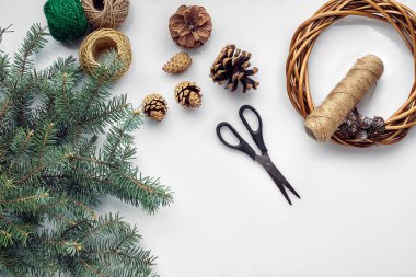 Güzel Festival el yapımı çelenk yakınında üç darbe ile temel, konu ve twigs düz yatıyordu beyaz masa arka plan, Noel ağacına mavi.