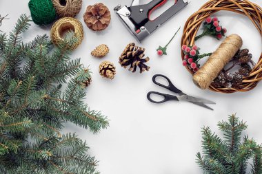 Güzel Festival el yapımı çelenk yakınında üç darbe ile temel, konu ve twigs düz yatıyordu beyaz masa arka plan, Noel ağacına mavi. Kopya alanı ile üstten görünüm