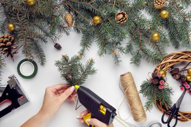 Eller üstten görünüm olun Noel çelenk. Yemeği hediyeler ve verilirse, şube ve beyaz masa üstünde alet çeki düzen vermek.