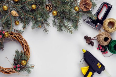 Yaratıcı Noel DIY. Kadın yapımı el yapımı Noel çelenk. Ev eğlence, Araçlar, ıvır zıvır ve Ayrıntılar için tatil dekorasyon beyaz masa arka plan üzerinde. Üstten görünüm