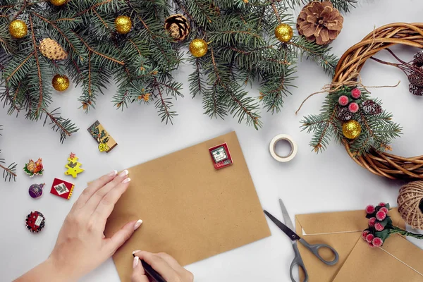 Eller neşeli Noel kartı ve zarf tutun. Noel dekorasyon arka plan. Düz yatıyordu, en iyi görünümü.