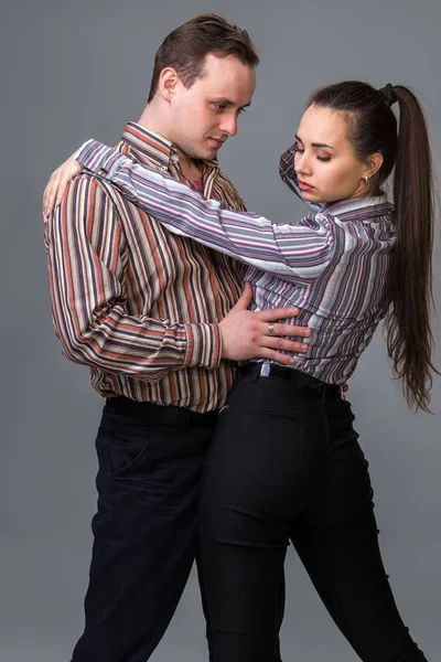 Una pareja posando en el estudio. Sobre fondo gris — Foto de Stock