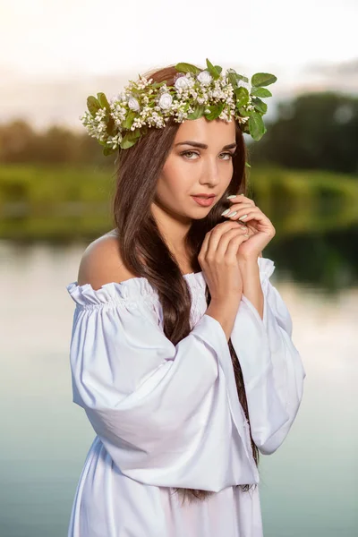 Woman in white dress in the water. Art Woman with wreath on her head in river. Wreath on her head, Slavic traditions and paganism