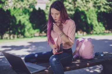 Kadın par ahşap bir bankta oturmuş bir defter yazma