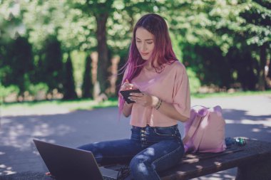 Kadın par ahşap bir bankta oturmuş bir defter yazma