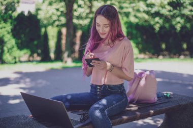 Kadın par ahşap bir bankta oturmuş bir defter yazma