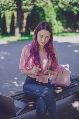 Kadın par ahşap bir bankta oturmuş bir defter yazma