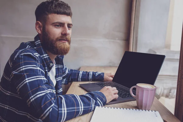 Joven charlando vía net-book durante las vacaciones de trabajo en la cafetería — Foto de Stock