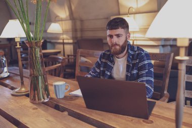 Genç profesyonel bir kafede onun Laptop Internet sörf