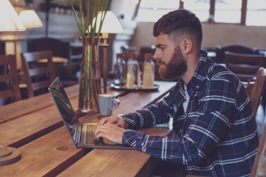 Genç profesyonel bir kafede onun Laptop Internet sörf