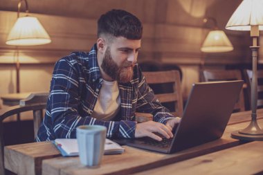 Genç profesyonel bir kafede onun Laptop Internet sörf