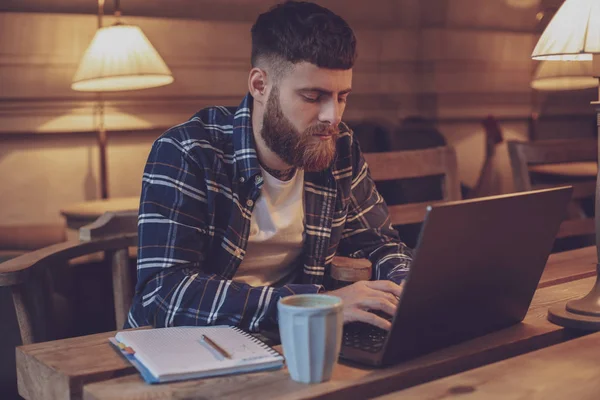 Joven profesional navegando por Internet en su portátil en un café — Foto de Stock