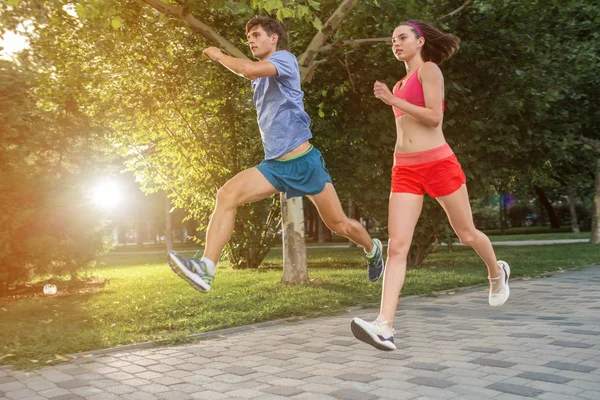 Retrato de casal caucasiano alegre correndo ao ar livre — Fotografia de Stock