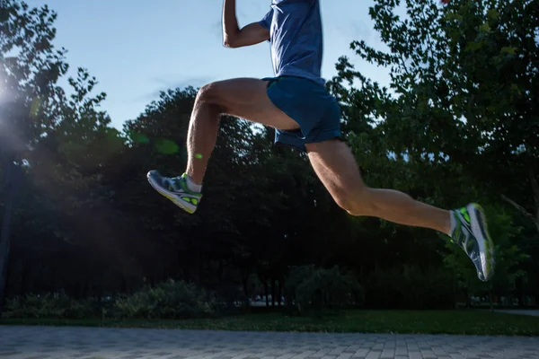 Hombre corriendo en el parque de la ciudad al atardecer — Foto de Stock