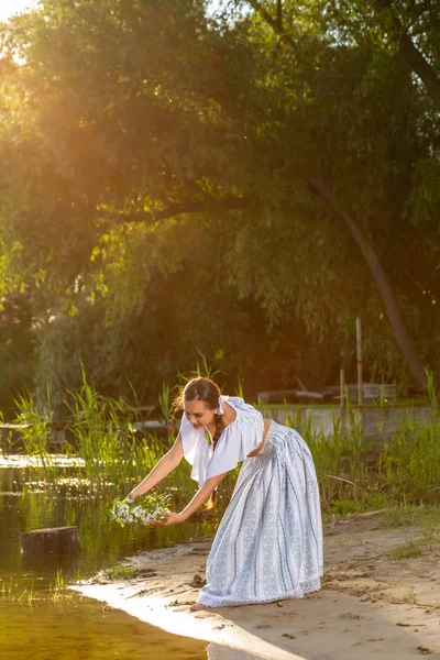 Fiatal gyönyörű kaukázusi nő-folyó partján áll. Táj kép a festő- és másol space lány. Napsütés fáklyát — Stock Fotó