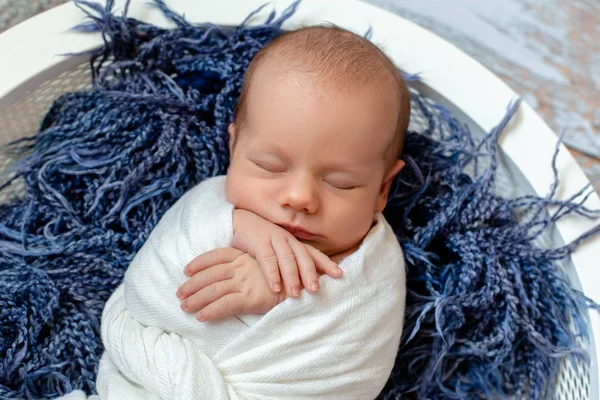 Baby jongetje slapen in een mandje op de houten vloer, studio opname — Stockfoto