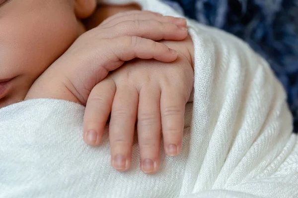 작은 아기의 클로즈업을 처리합니다. 화이트 니트 담요 아래 자 신생아 보 블루 모피에 거짓말. — 스톡 사진