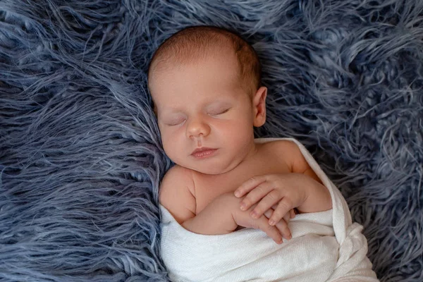Pasgeboren babyjongen in bed. Nieuwe geboren kind slapen onder een wit gebreid deken. Kinderen slapen. — Stockfoto