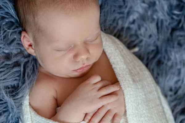 Pasgeboren babyjongen in bed. Nieuwe geboren kind slapen onder een wit gebreid deken. Kinderen slapen. — Stockfoto