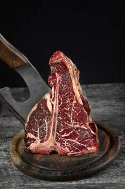 Deniz tuzu ve bir mutfak balta ile zeytin ahşap panosunda taze çiğ t-bones biftek.