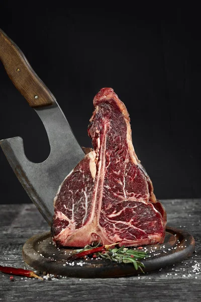 Filete fresco crudo de huesos en una tabla de madera de olivo con sal marina y un hacha de cocina . — Foto de Stock