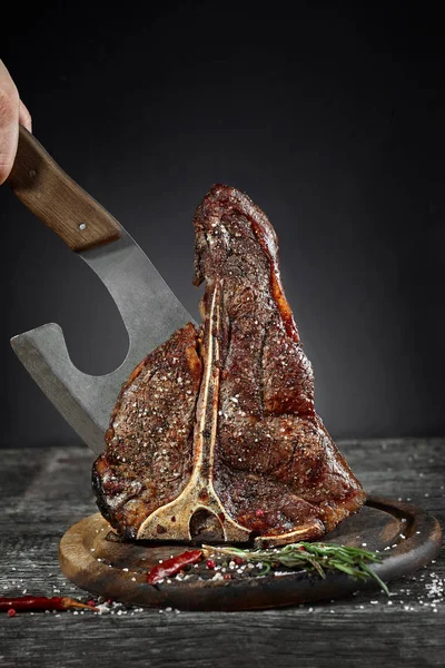 Grilované steaky solí a pepřem na prkénku na tmavém pozadí — Stock fotografie