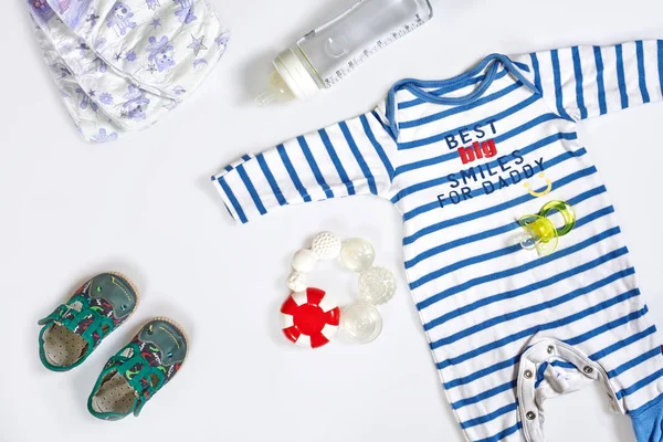Acessórios para cuidados com o bebê e roupas no fundo branco, vista superior — Fotografia de Stock