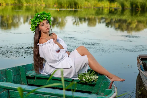 A nimfa a hosszú, sötét haj, egy fehér vintage ruha a folyó közepén egy csónakban ül. — Stock Fotó