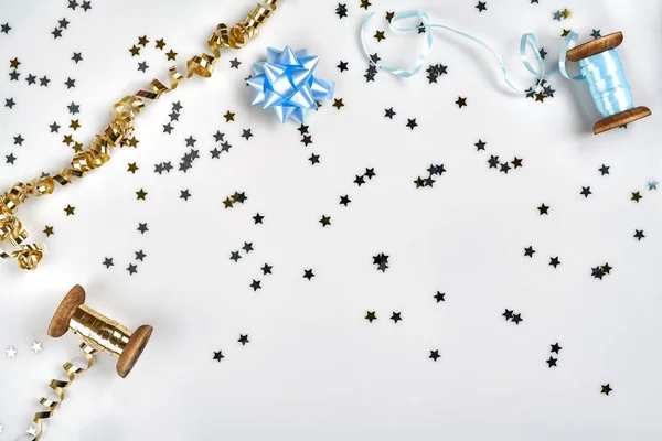 精致的波浪色丝带和金属星状的五彩纸屑在白色背景上被隔离。圣诞假期装饰理念. — 图库照片