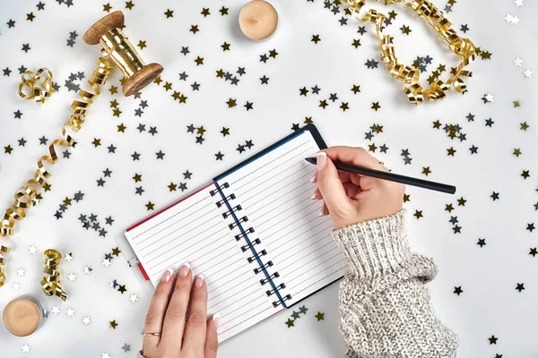 Decorações festivas, delicadas fitas onduladas, estrela metálica em forma de confete e notebook com lista de desejos na mesa branca, estilo flat lay. Natal feriados decoração conceito . — Fotografia de Stock