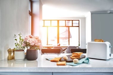 Sıcak sabah taze ekmek ile beyaz bir mutfakta. Güneş parlaması