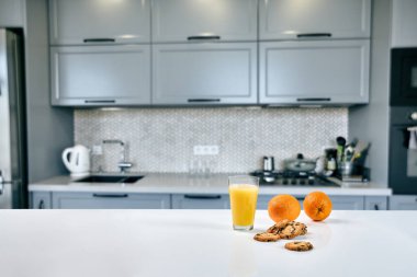 Cam mutfak masasında, arka plan bulanık portakal suyu ile tanımlama.