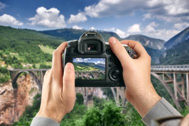 Dijital tek objektifli refleks kamera elinde. Adam fotoğrafçı fotoğraf yapar. Kamera yakın çekim erkek el ele tutuşur