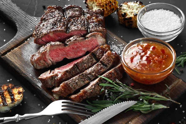 In Scheiben geschnitten gegrilltes mittelseltenes Rindersteak serviert auf Holzbrett Grill, Grillfleisch Rinderfilet. — Stockfoto