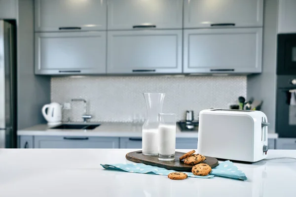 Kekse und Milch mit einer Glasmilchflasche auf dem Küchentisch für einen After-School-Snack mit Keksen und Milch — Stockfoto