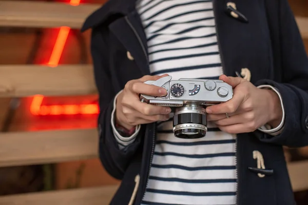 Flicka fotograf med en gammal kamera i händerna. — Stockfoto